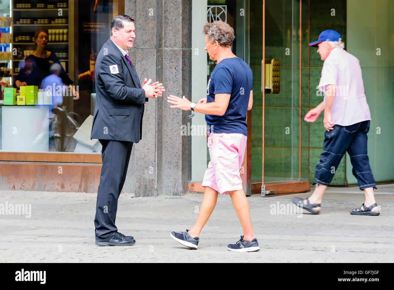 Goteborg, Svezia - 25 Luglio 2016: uomo sconosciuto in un vestito con un logo Addici parlando a un uomo a camminare verso di lui vestito in leisu Foto Stock