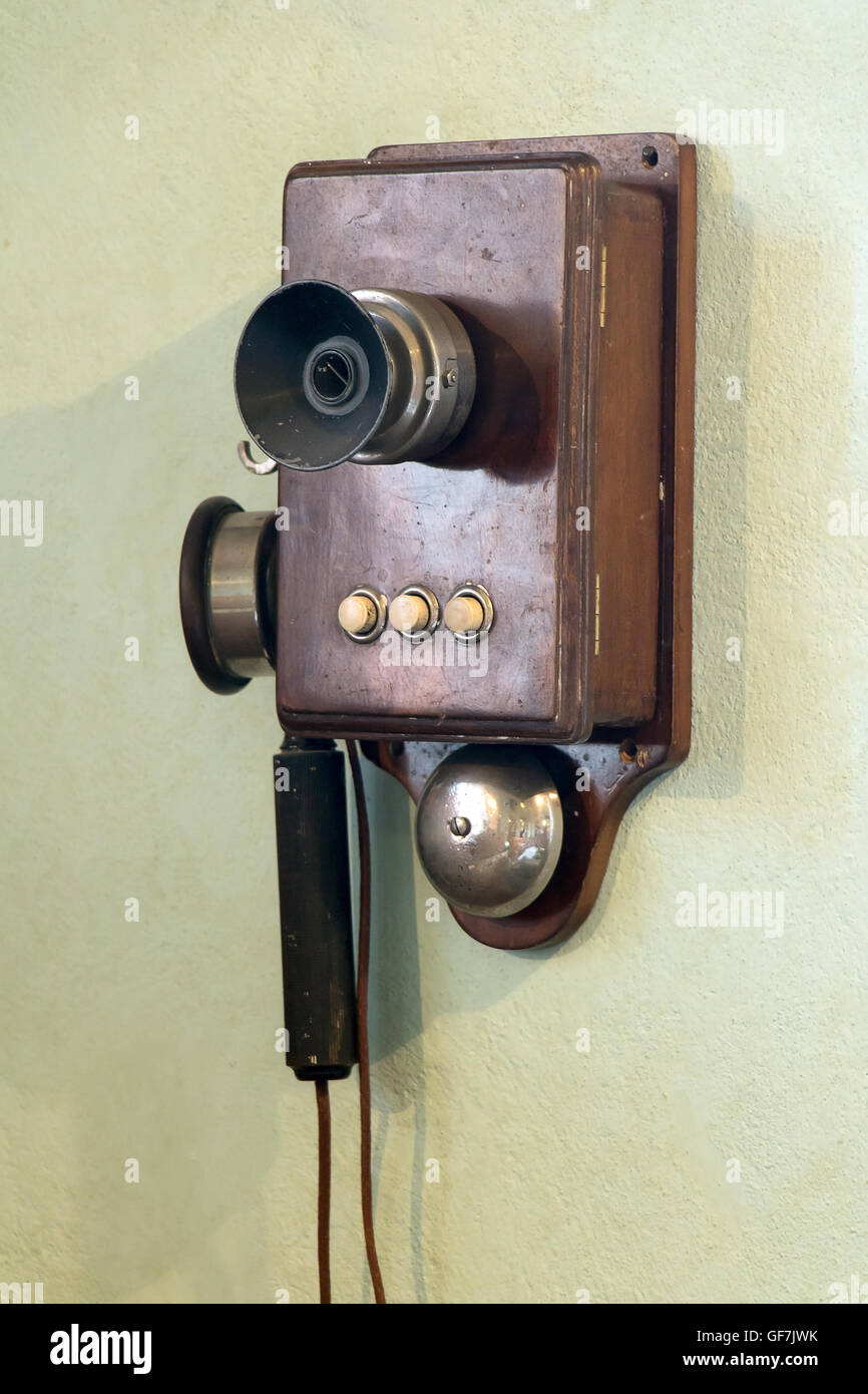 Il vecchio telefono con manovella si blocca sulla parete Foto Stock