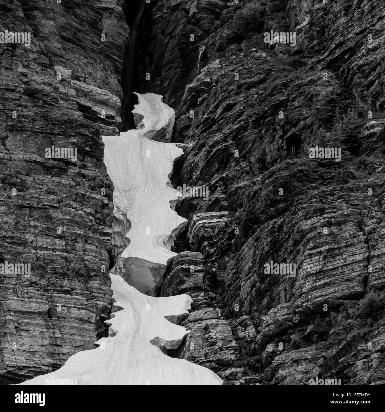 Il ghiaccio sospeso in crepaccio roccioso in bianco e nero Foto Stock