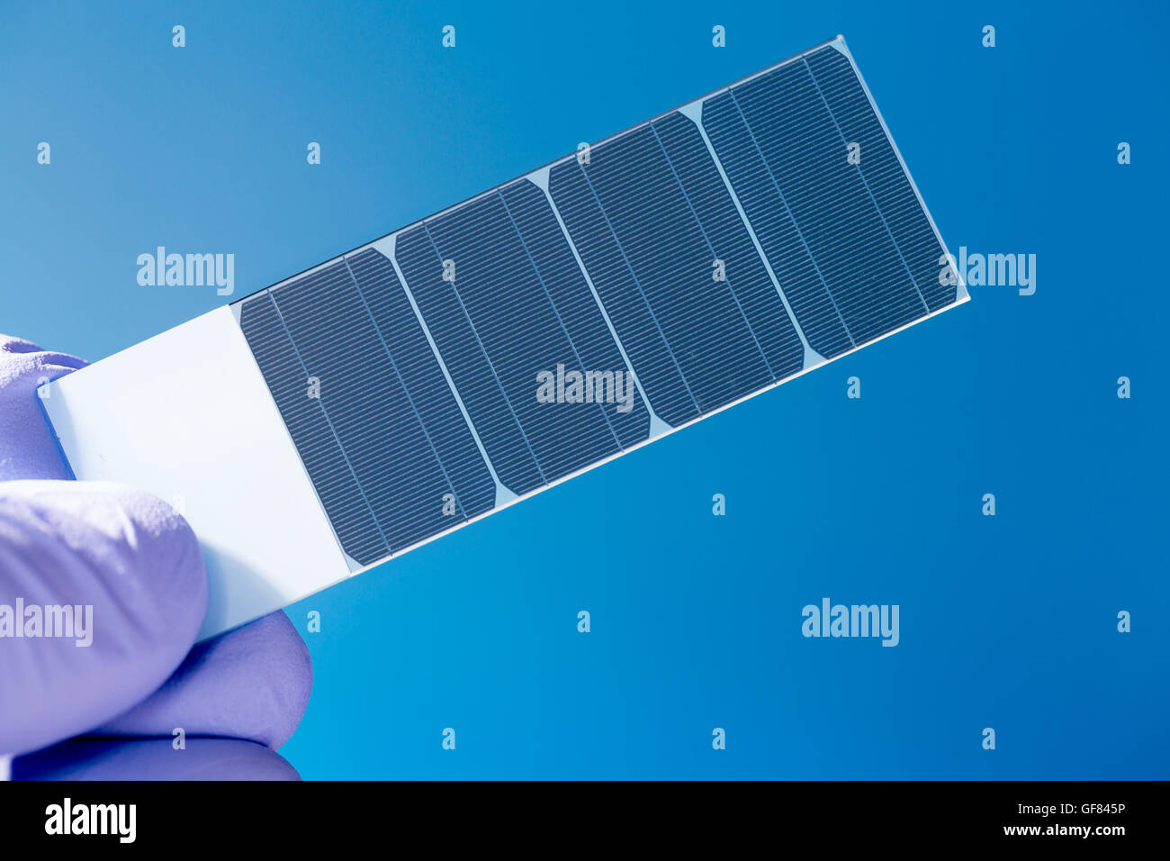 Un cristallo di silicio con celle fotovoltaiche in mano dello scienziato Foto Stock