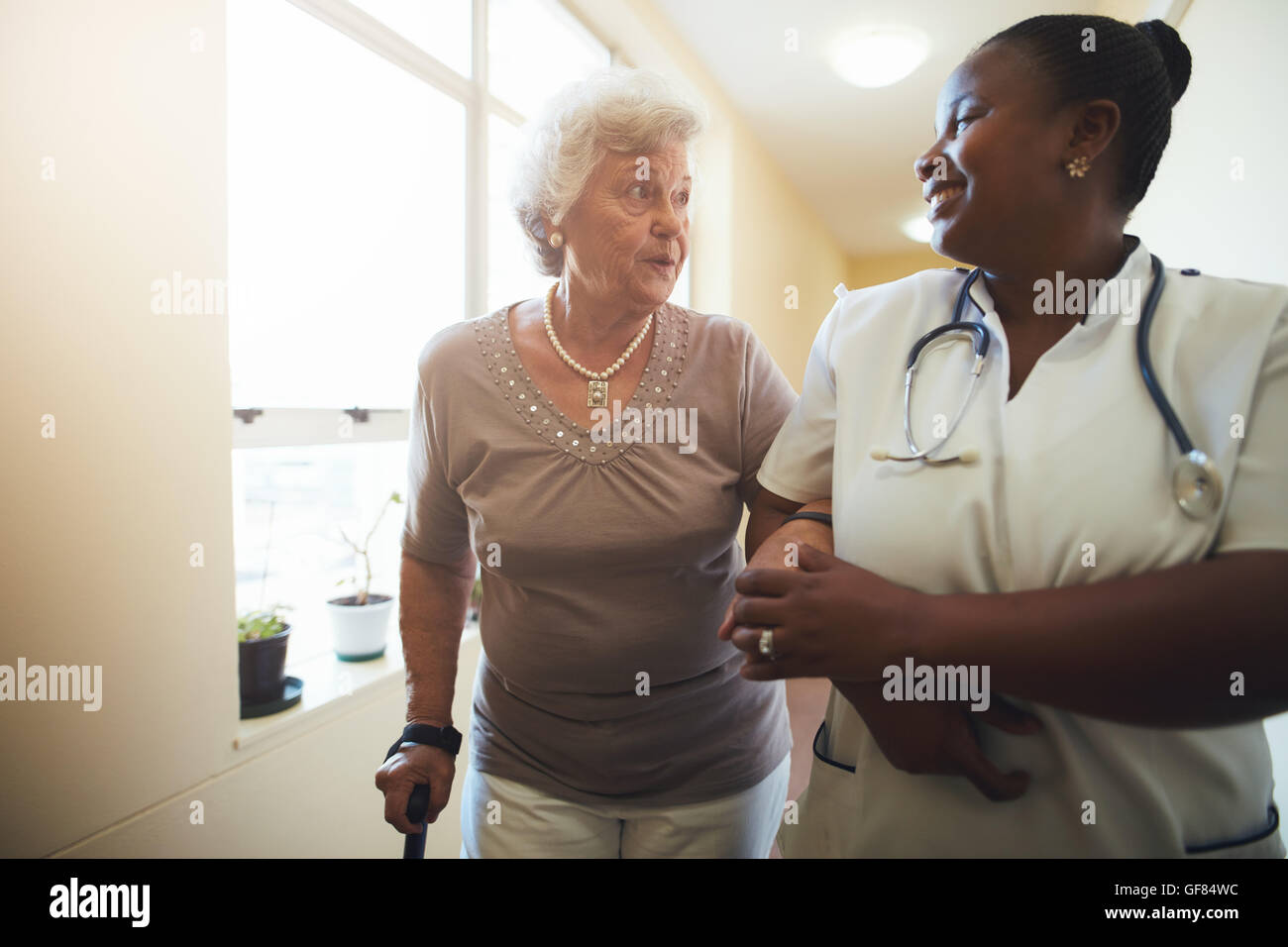 Ritratto di lavoratore del settore sanitario e senior donna camminare insieme. L'infermiera assistere senior paziente femmina mentre si cammina nel campo dell'assistenza infermieristica Foto Stock