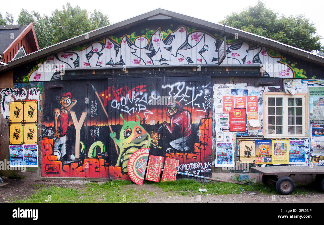 Graffiti colorati coprono un muro a Freetown Christiania, Copenhagen, che mostra la vivace controcultura e la scena artistica di strada della zona. Foto Stock