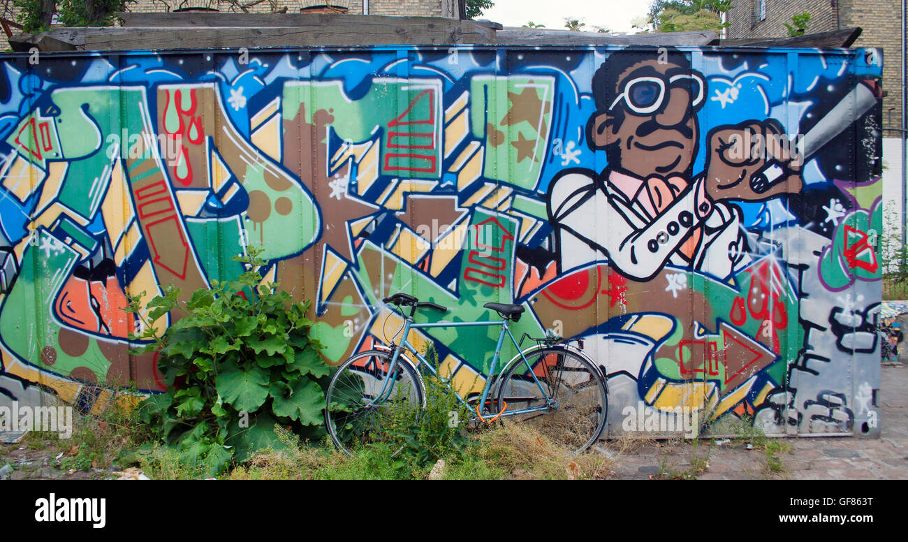 Graffiti colorati coprono un muro a Freetown Christiania, Copenhagen, che mostra la vivace controcultura e la scena artistica di strada della zona. Foto Stock