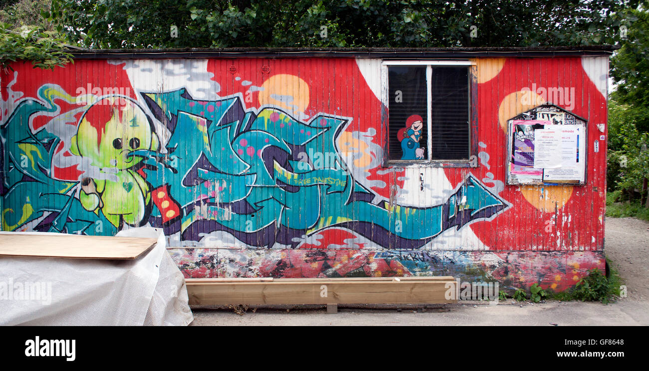 Graffiti artistici su un muro a Freetown Christiania, Copenhagen, Danimarca, che mostrano audaci Street art, controcultura ed espressione creativa. Foto Stock