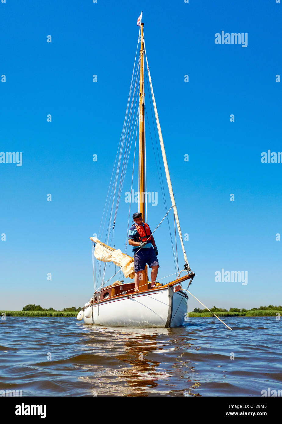 Un uomo in pensione e il suo yacht classico Foto Stock