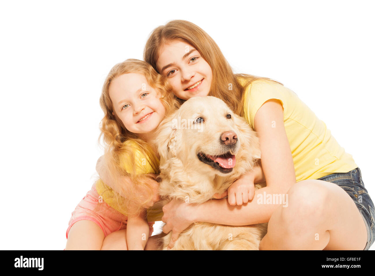 Due ragazze bionda abbracciando le loro Golden Retriever Foto Stock