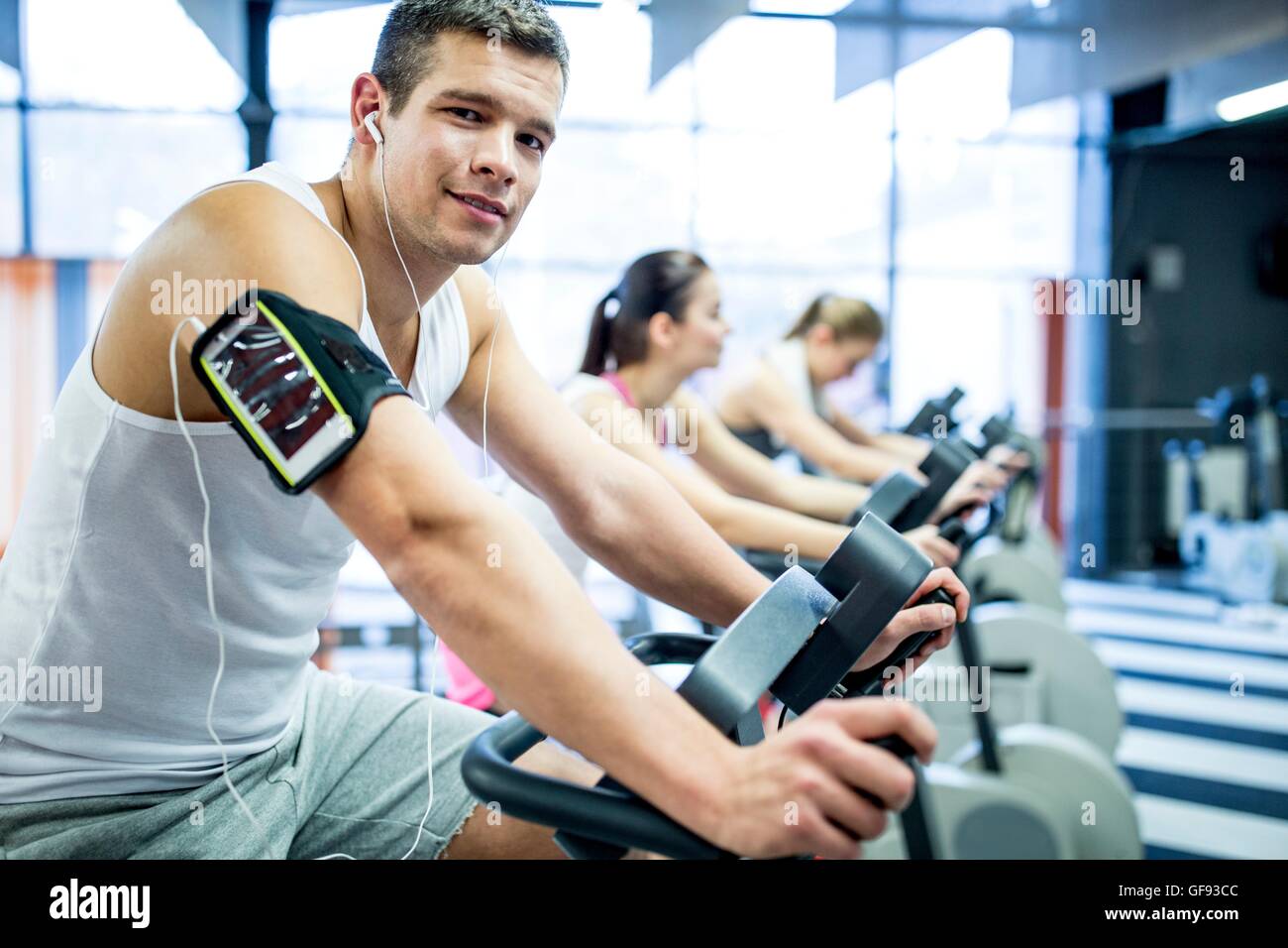 Proprietà rilasciato. Modello rilasciato. Giovane uomo ascoltare musica mentre il lavoro in palestra, ritratto. Foto Stock