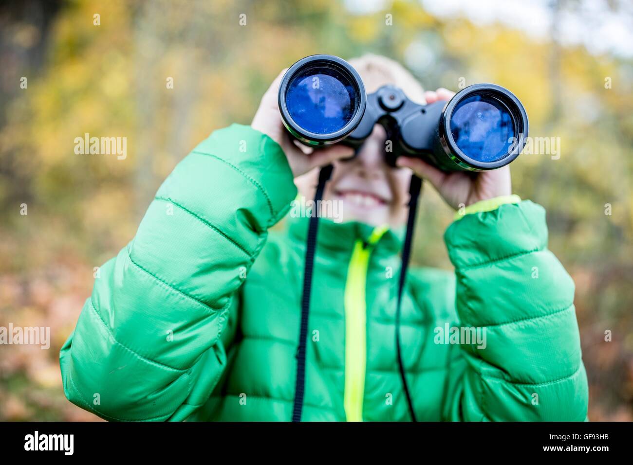 Modello rilasciato. Ragazzo che guarda attraverso il binocolo, close-up. Foto Stock