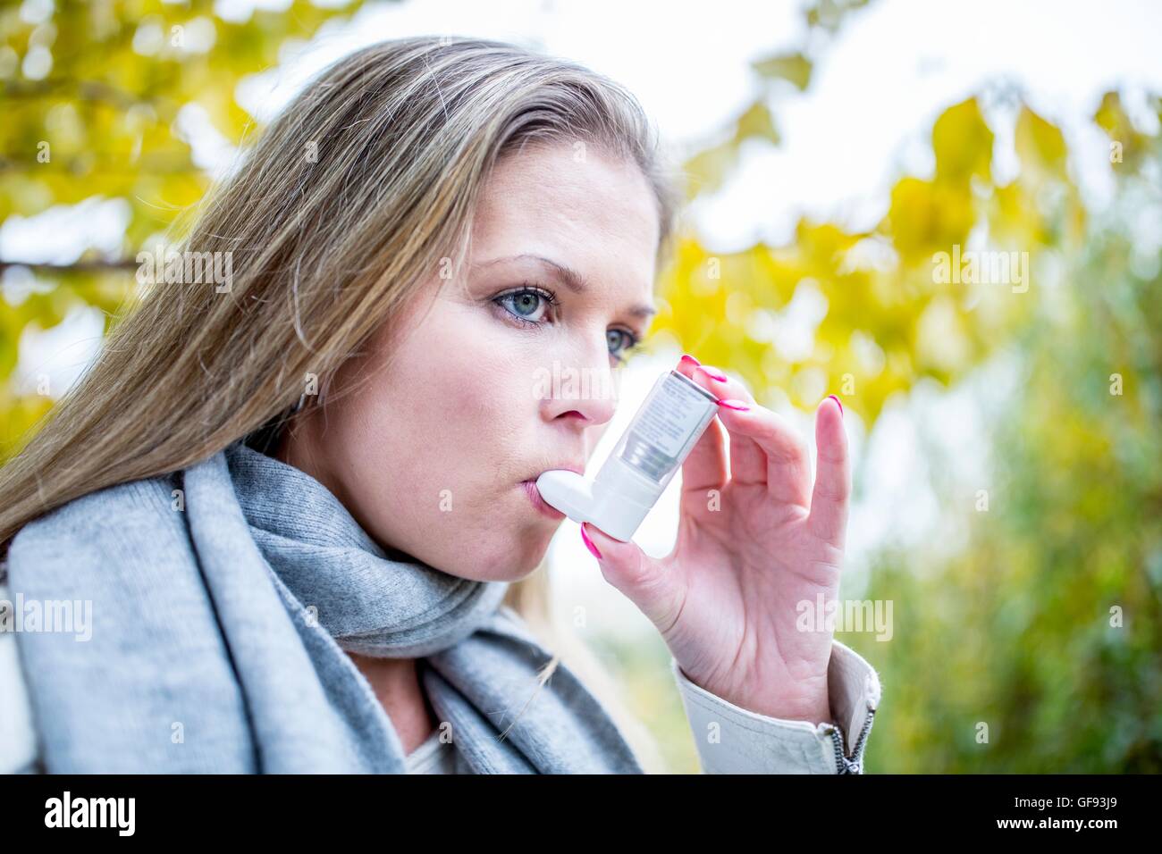 Modello rilasciato. Giovane donna con asma inalatore, close-up. Foto Stock