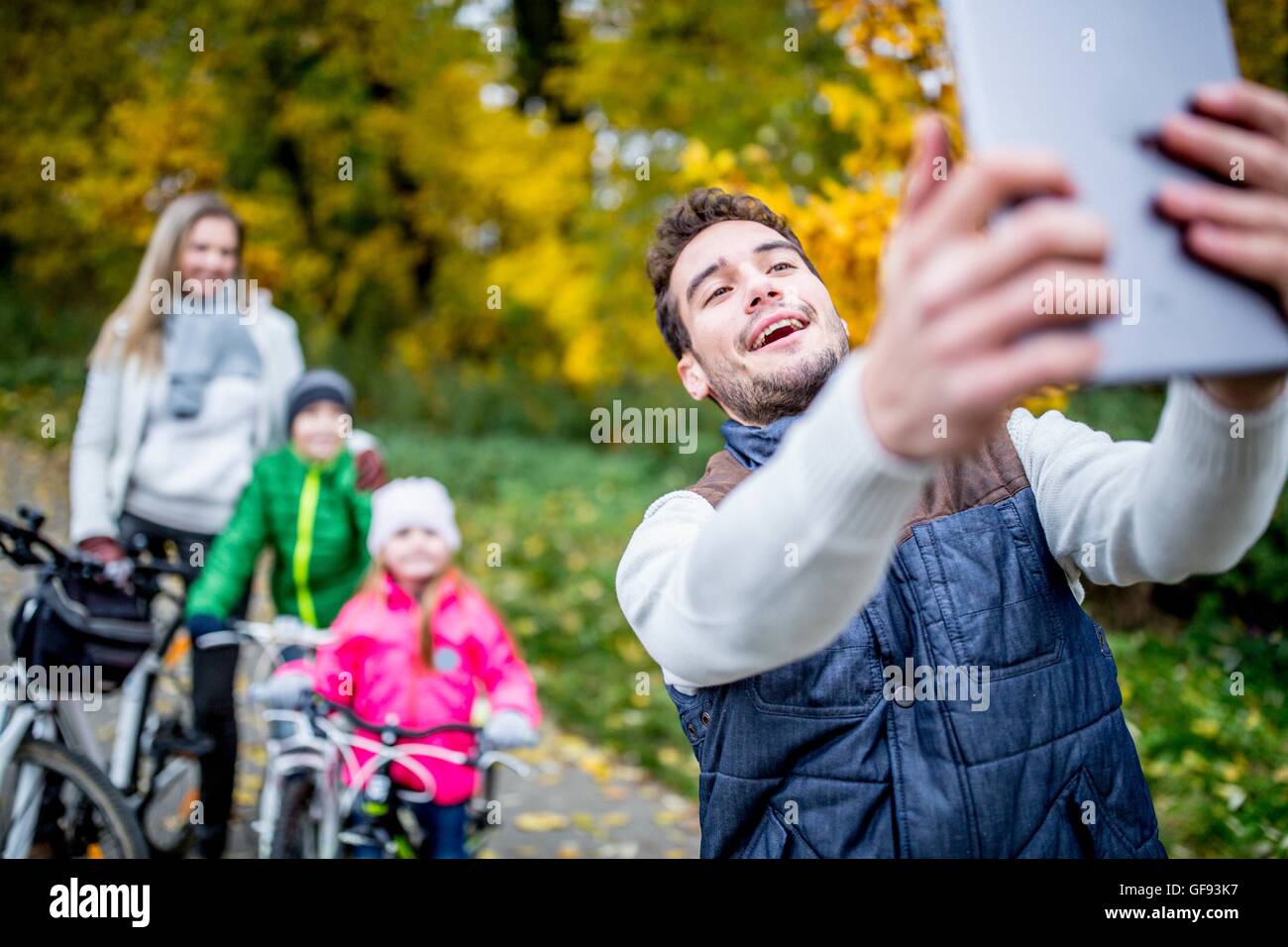 Modello rilasciato. Uomo sorridente prendendo foto di famiglia. Foto Stock