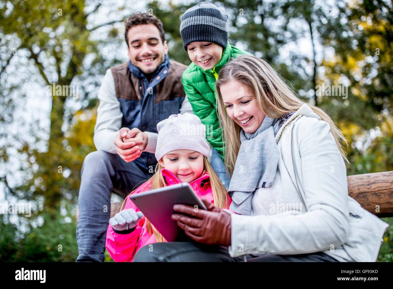 Modello rilasciato. La famiglia tramite tavoletta digitale in autunno. Foto Stock