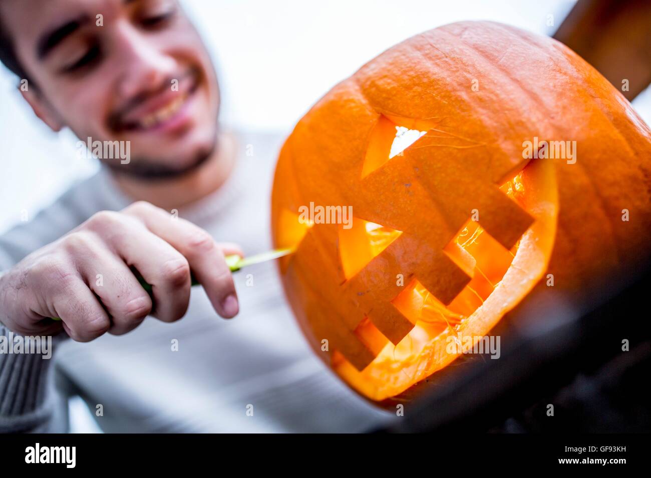 Modello rilasciato. L'uomo rendendo la zucca di Halloween. Foto Stock