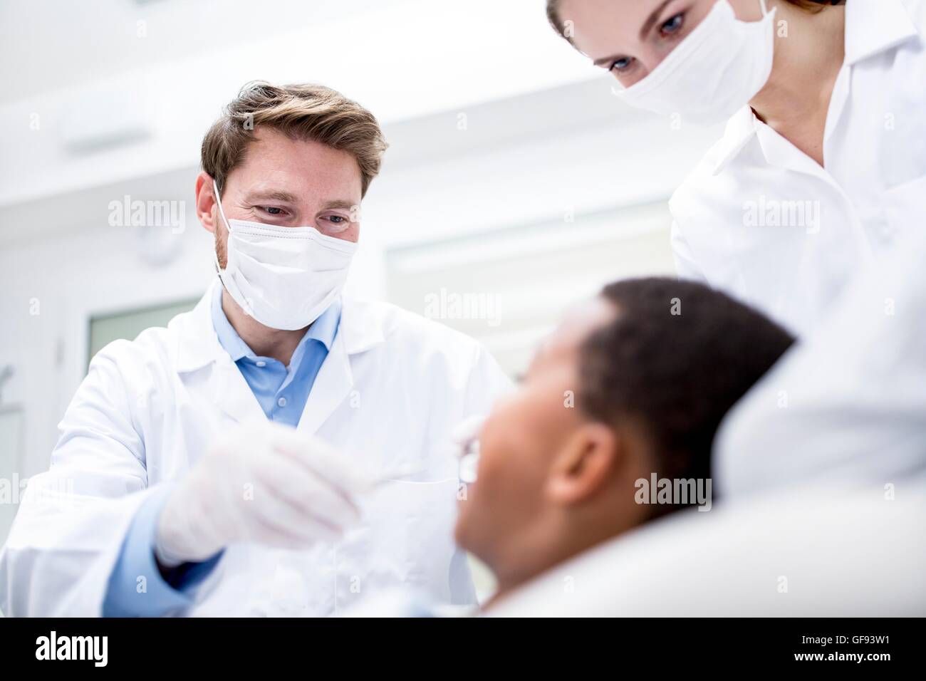 Modello rilasciato. Dentista esame paziente con la sua assistenza. Foto Stock