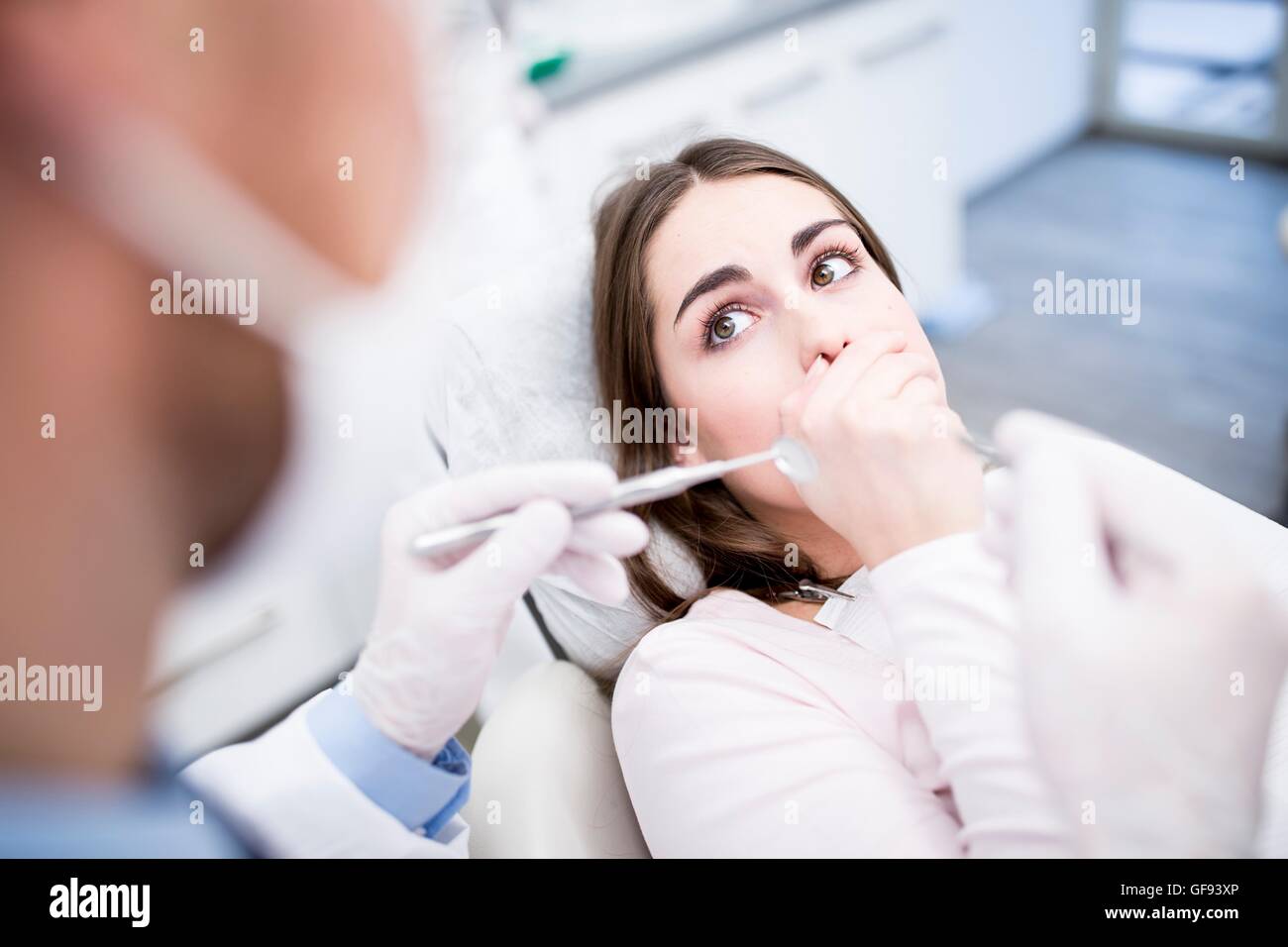Modello rilasciato. Scioccato paziente guardando al dentista di dentista clinica. Foto Stock
