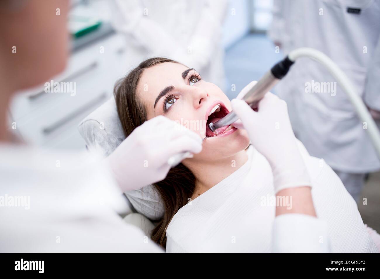 Modello rilasciato. Giovane donna ottenendo il suo denti esaminati dal dentista. Foto Stock