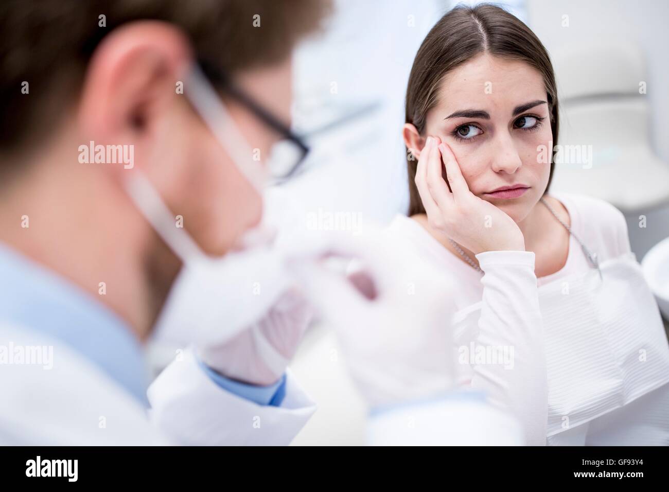 Modello rilasciato. Paziente triste guardando al dentista di dentista clinica. Foto Stock