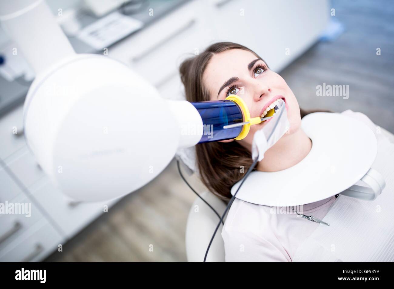 Modello rilasciato. Giovane donna avente apparecchiature odontoiatriche a raggi x in clinica. Foto Stock