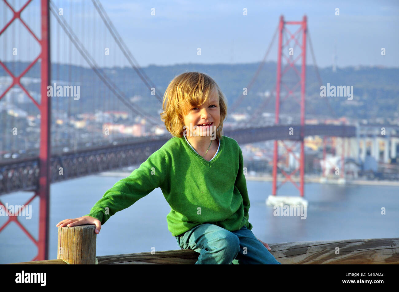 Ragazzo sorridente in corrispondenza del ponte Golden Gate' a Lisbona, Portogallo Foto Stock