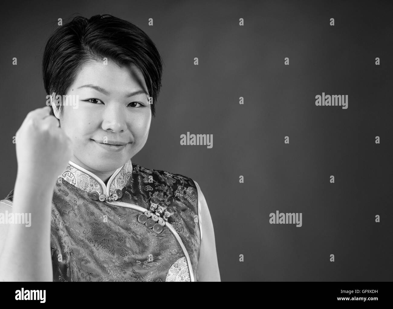 Modello femminile donna attraente su sfondo semplice con spazio copia sconvolto Mostra pugno Foto Stock