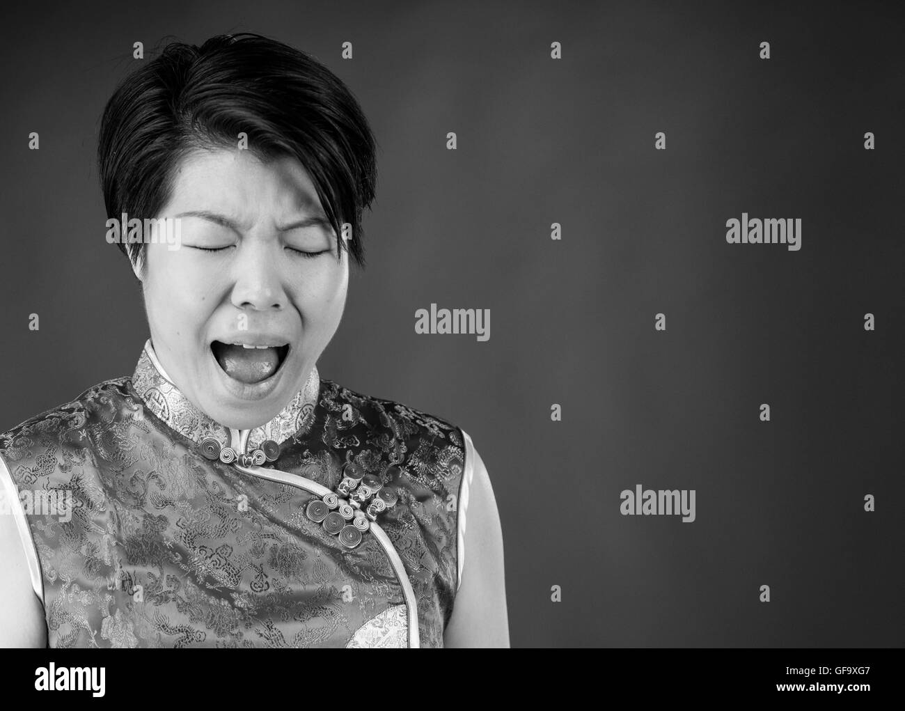 Modello femminile donna attraente su sfondo semplice con spazio copia urlando frustrazione Foto Stock