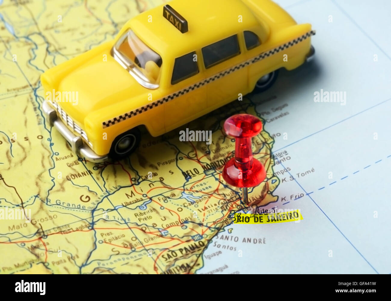 Close-up di una puntina rossa su una mappa di Rio de Janeiro e un taxi auto - Concetto di viaggio Foto Stock