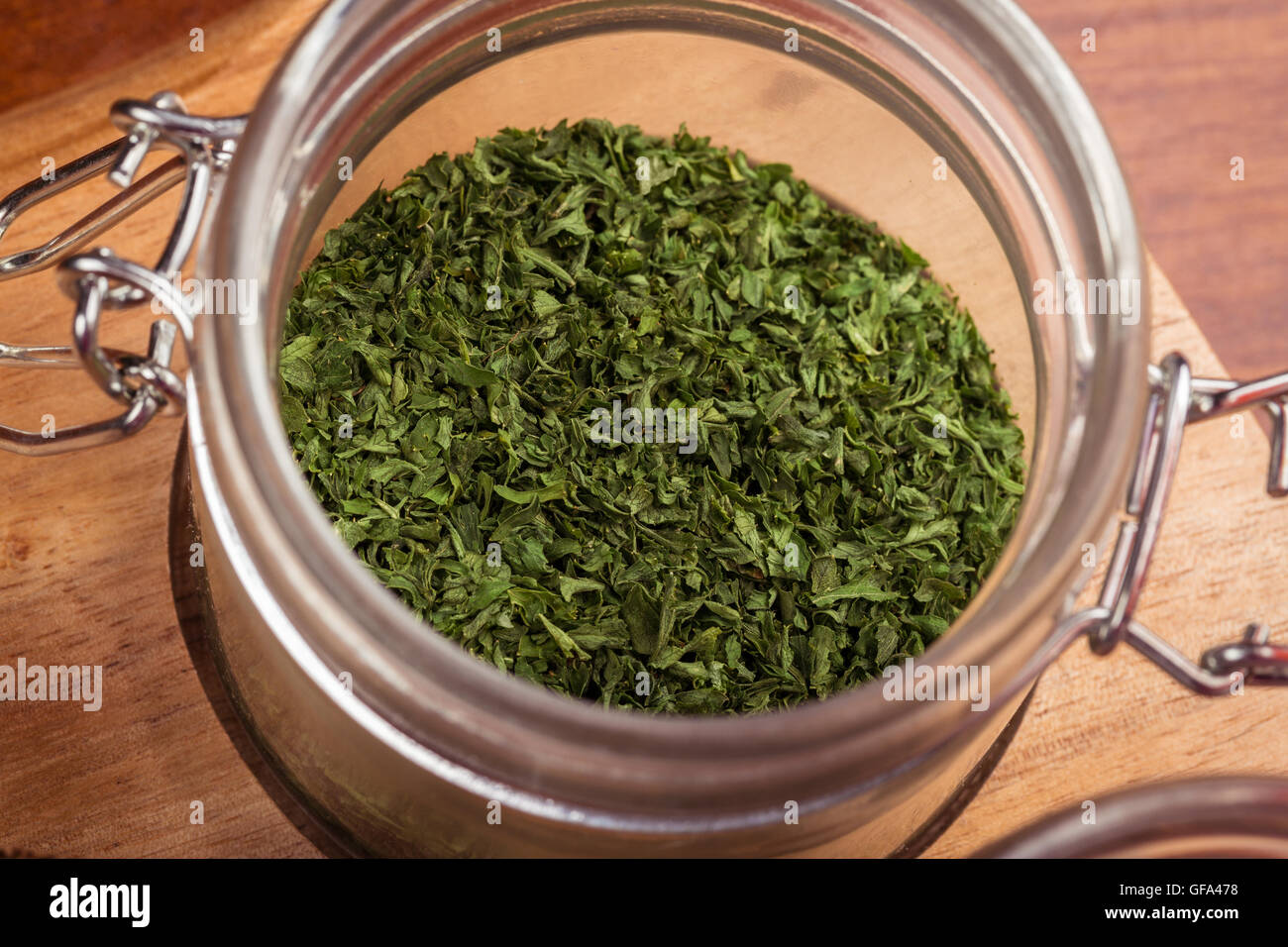 Basilico essiccato in un vasetto di vetro, utilizzata come un semplice per aggiunta di meraviglioso sapore ai cibi. Foto Stock