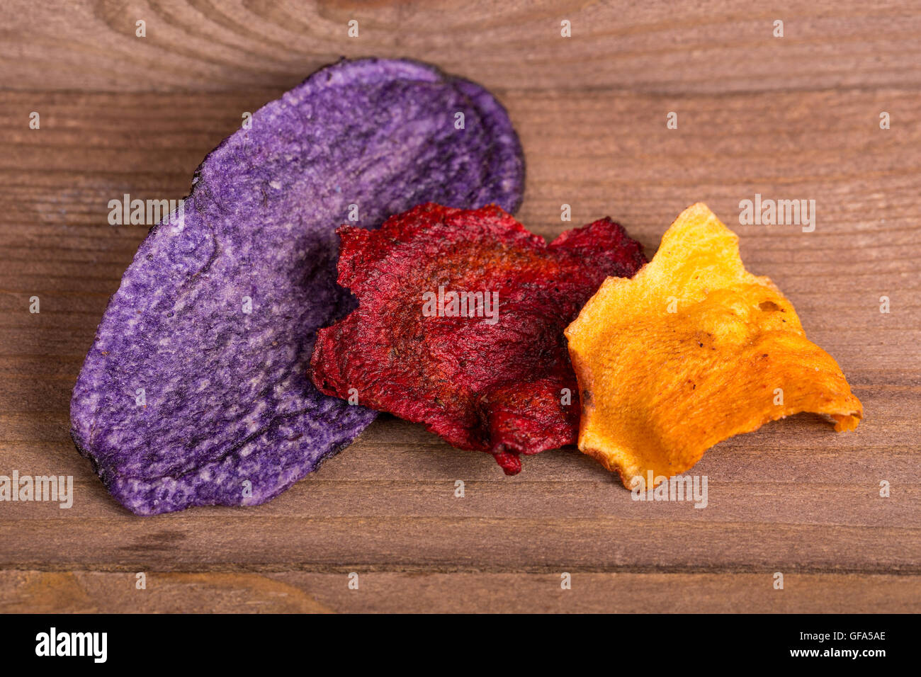 Tre diversi tipi e colori di patatine vegetali (o chips in alcuni paesi) - viola di patate, barbabietole e pastinaca. Foto Stock