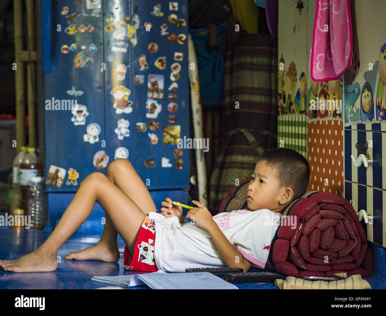 Luglio 30, 2016 - Bangkok Bangkok, Tailandia - un bambino guarda la televisione nella sua casa il Pom Mahakan Fort slum. I residenti delle baraccopoli è stato detto che essi devono lasciare il forte e che la loro comunità saranno abbattute. Il forte era uno dei 14 fortezze progettato per proteggere Bangkok da invasori stranieri. Solo dei due rimanenti, le altre sono state abbattute. Una comunità sviluppata nel forte quando la gente ha cominciato a costruire case e passando in esso durante il regno del Re Rama V (1868-1910). Il terreno è stato espropriato dalla città di Bangkok di governo nel 1992, ma le persone che vivono in fort rifiutare Foto Stock