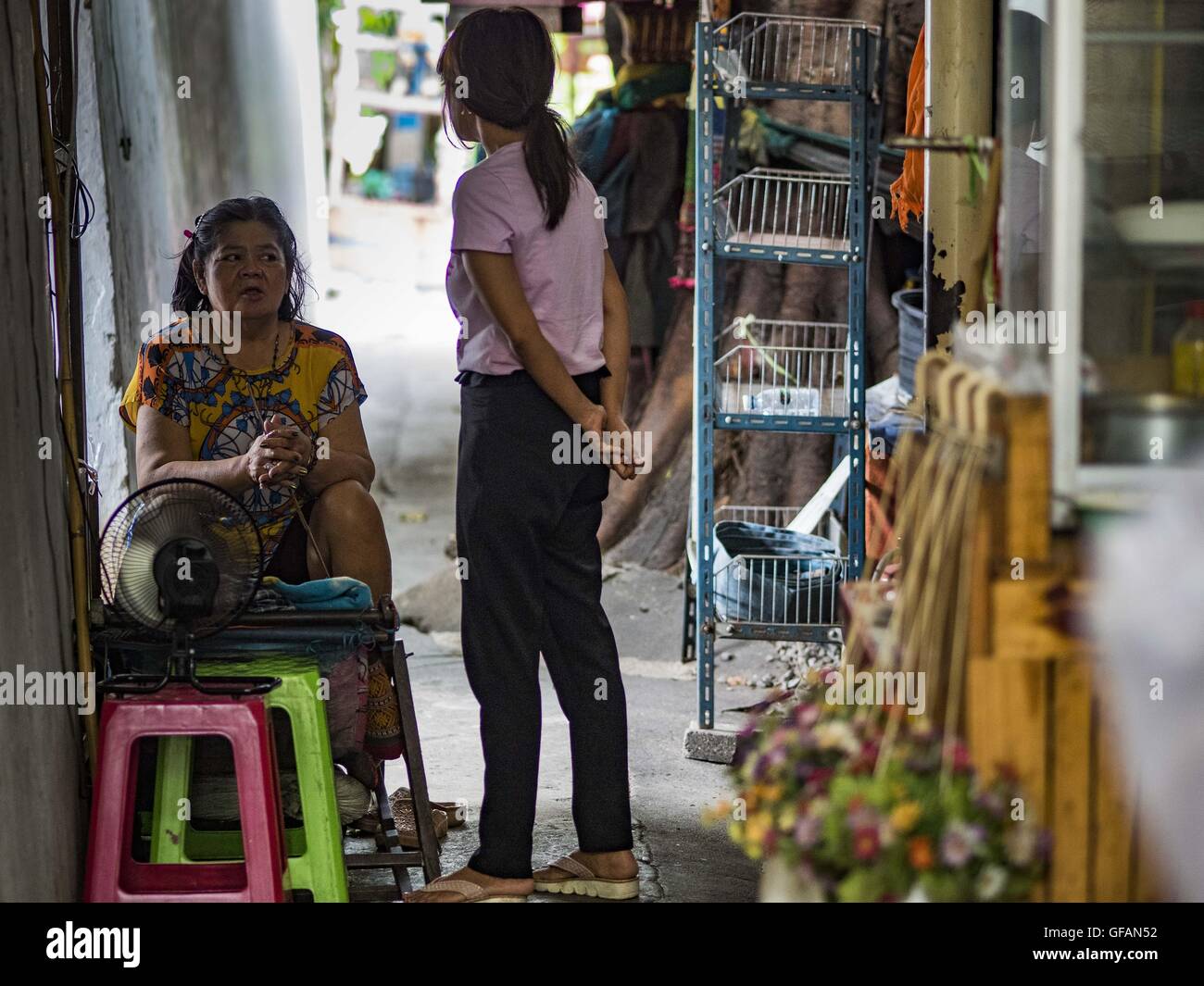 Luglio 30, 2016 - Bangkok Bangkok, Thailandia - Donne in chat in un vicolo del Pom Makahan Fort slum. I residenti delle baraccopoli è stato detto che essi devono lasciare il forte e che la loro comunità saranno abbattute. Mahakan Fort fu costruita nel 1783 durante il regno del re Siamese Rama I. era uno dei 14 fortezze progettato per proteggere Bangkok da invasori stranieri. Solo dei due rimanenti, le altre sono state abbattute. Una comunità sviluppata nel forte quando la gente ha cominciato a costruire case e passando in esso durante il regno del Re Rama V (1868-1910). Il terreno è stato espropriato dalla città di Bangkok di governo Foto Stock