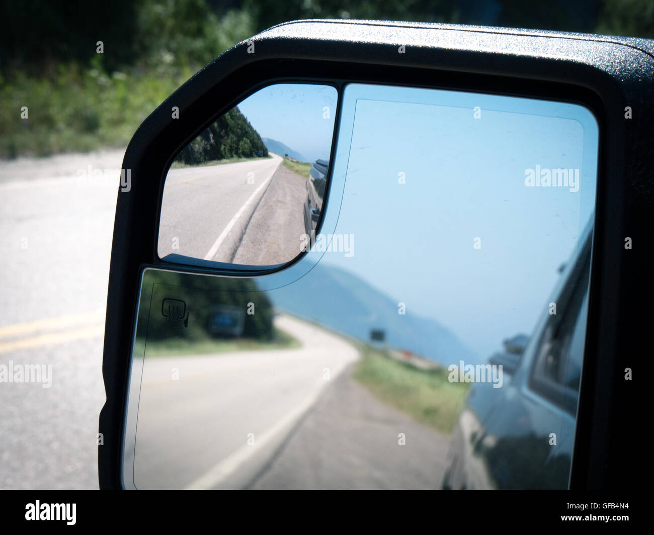 Strada lungo la collina in uno specchio retrovisore durante il periodo estivo Foto Stock