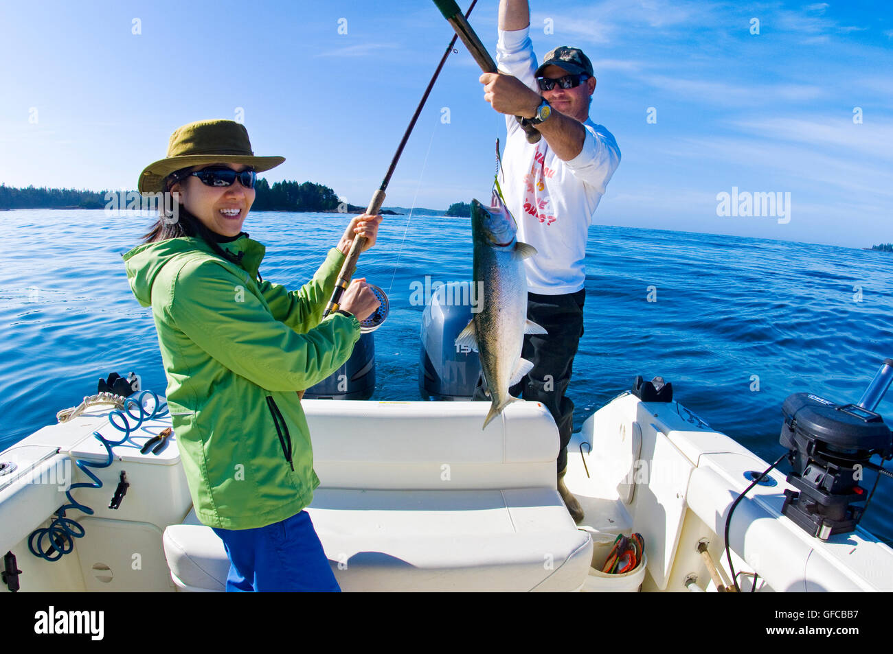 Asian lady avendo appena preso un coho salmone con guida di pesca a Clayoquot Sound in una limpida giornata di sole Foto Stock