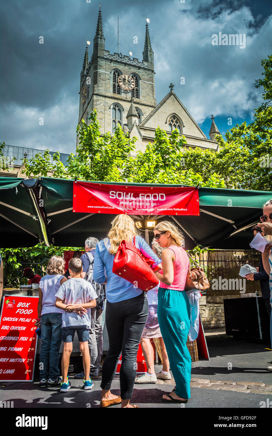 I clienti si accodano di fronte a una bancarella di cibo di fronte alla cattedrale di Southwark a Londra, Regno Unito Foto Stock