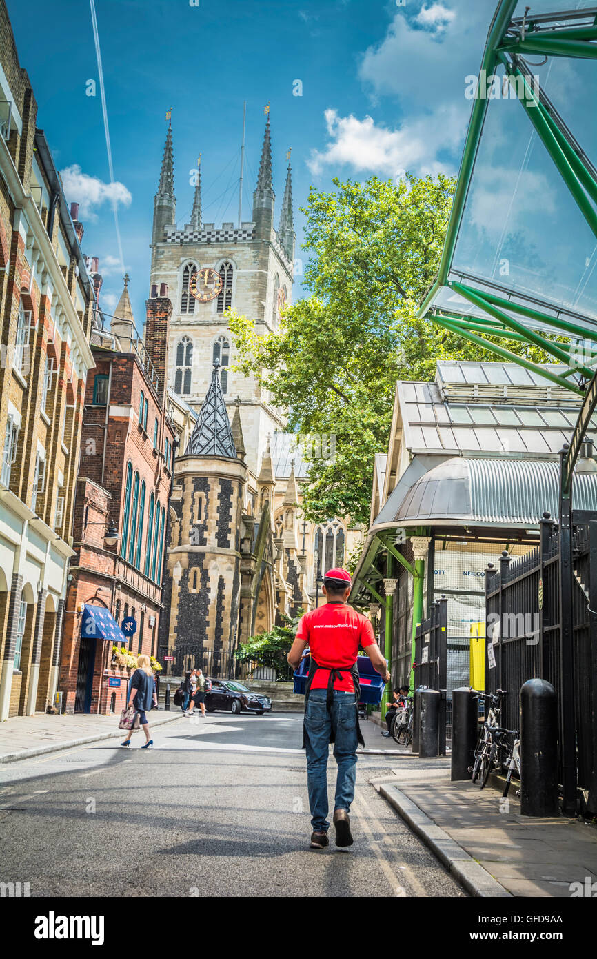 Un uomo che cammina lungo una bella strada laterale che conduce fino alla Cattedrale di Southwark a Londra, Regno Unito Foto Stock