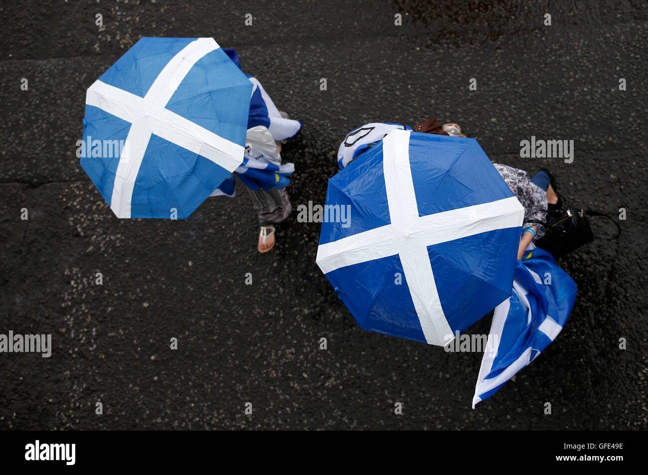 Le persone in attesa di ombrelli che prendono parte al 'Tutti sotto uno striscione' marzo per scozzese indipendenza attraverso il centro della città di Glasgow. Foto Stock