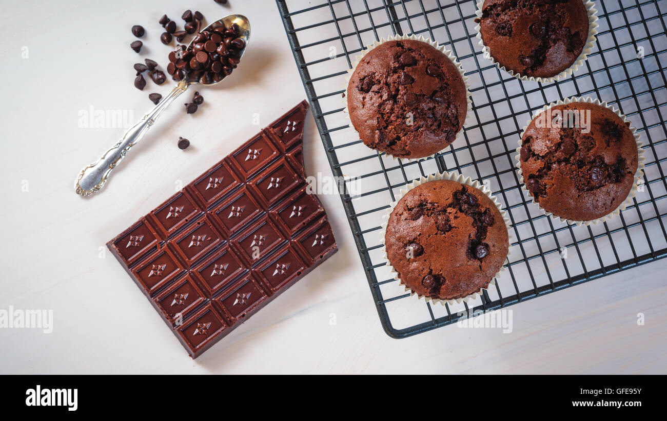 Muffin al cioccolato con una barretta di cioccolato e rosso frutti di melograno. Foto Stock