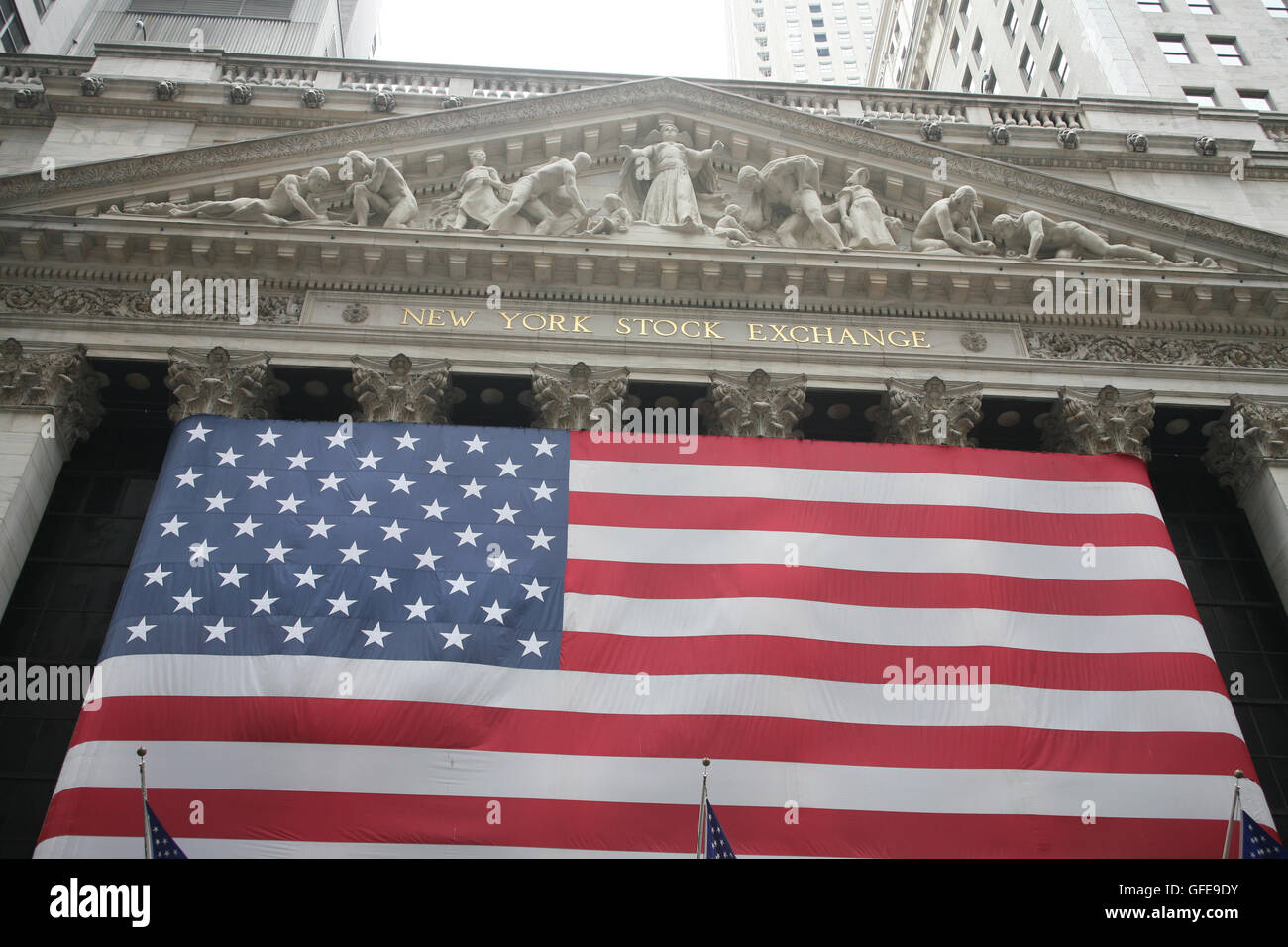 New York Stock Exchange a Wall Street con la bandiera americana su facciate Foto Stock