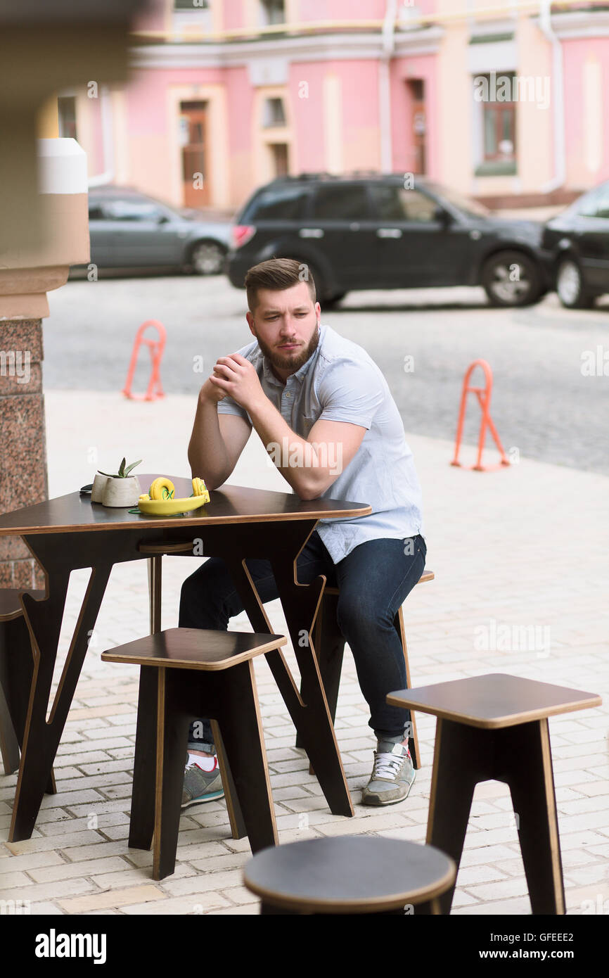 Bel uomo seduto in outdoor cafe vegano Foto Stock