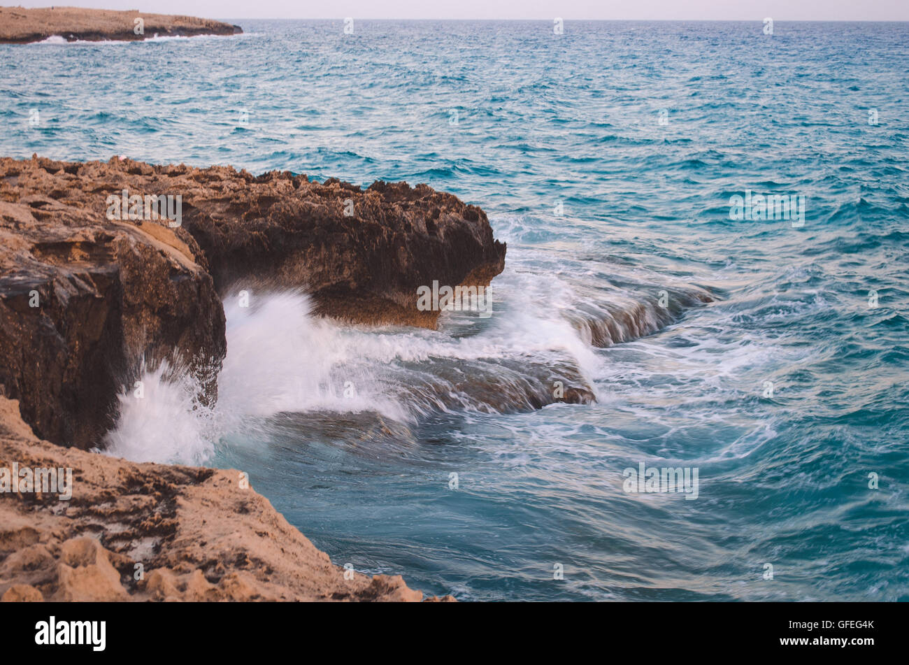 Onda oceano rompendo l'acqua di mare sulla spiaggia rocciosa Foto Stock