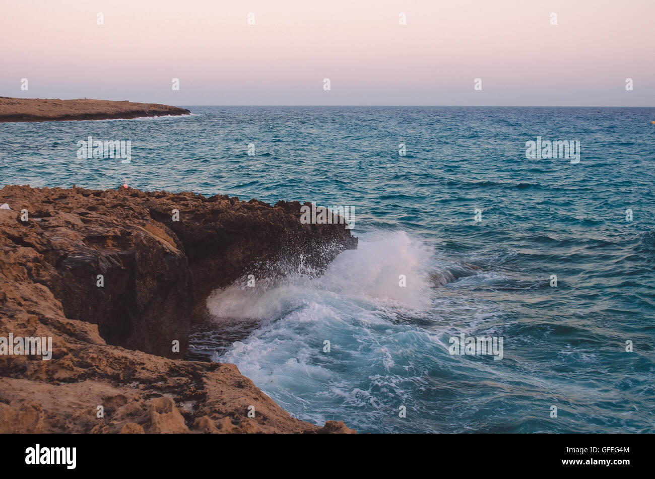 Onda oceano rompendo l'acqua di mare sulla spiaggia rocciosa Foto Stock