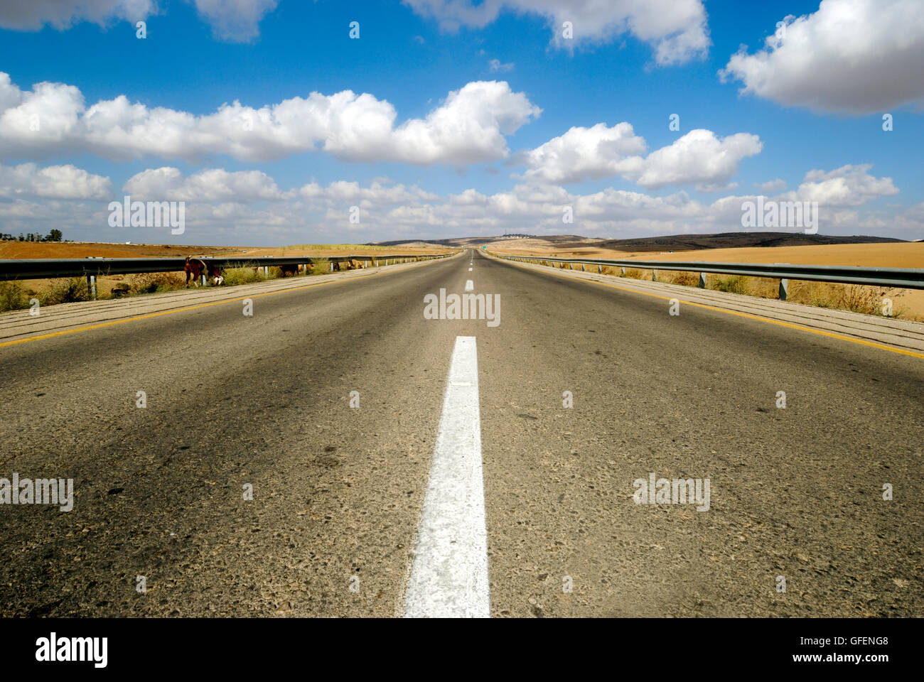 Australian, western New South Wales, infinite Road to Nowhere acceso all'orizzonte il cielo blu con nuvole Foto Stock