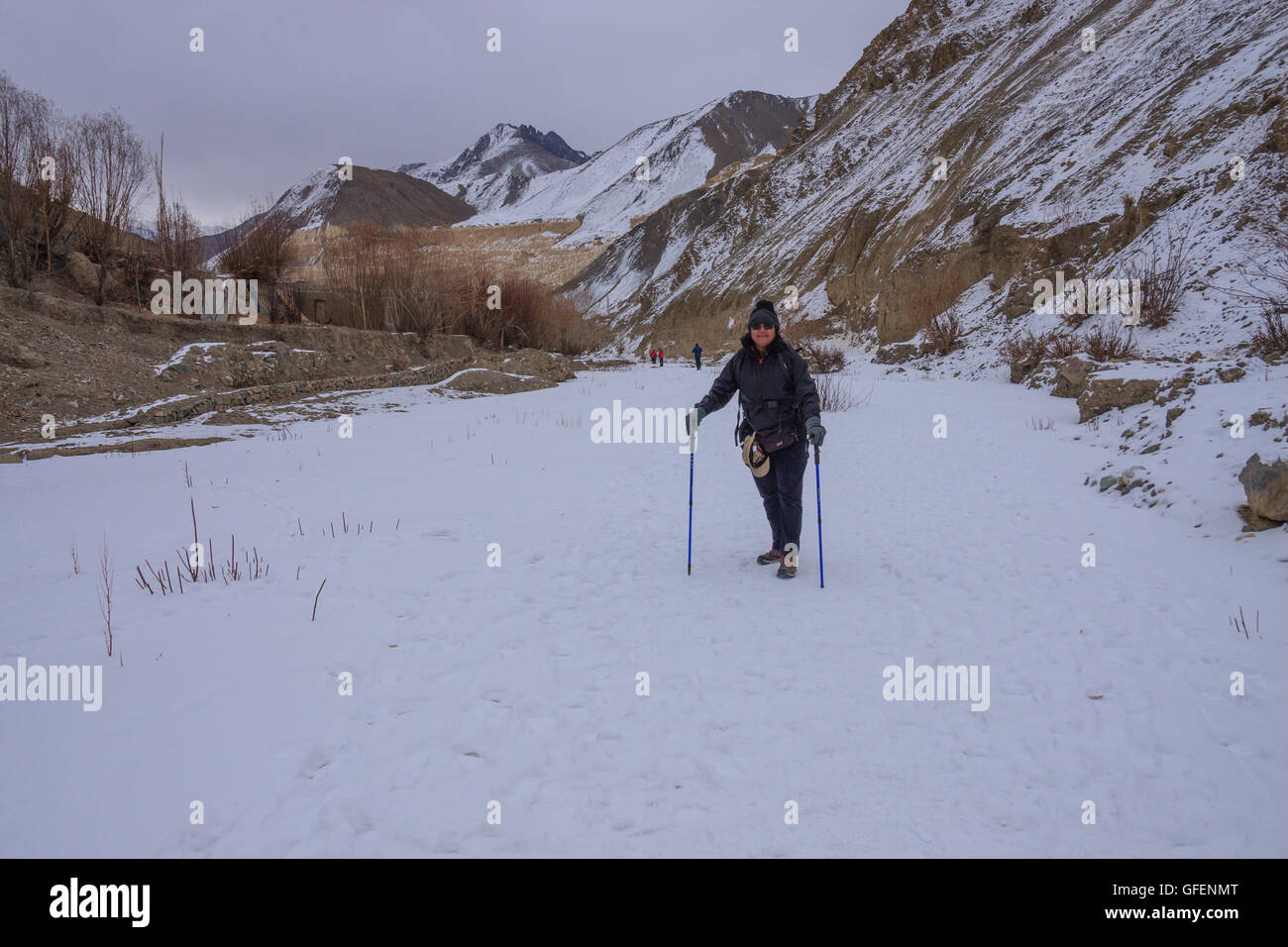 A Lady trekking in Ladakh (India) durante la stagione invernale attraverso il paesaggio innevato Foto Stock