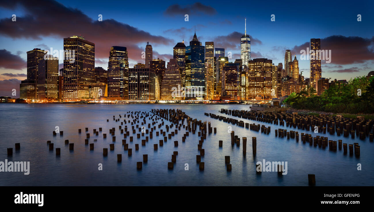 Panoramica di Lower Manhattan Financial District al crepuscolo con molo vecchio palificazioni di legno e il World Trade Center. La città di New York Foto Stock