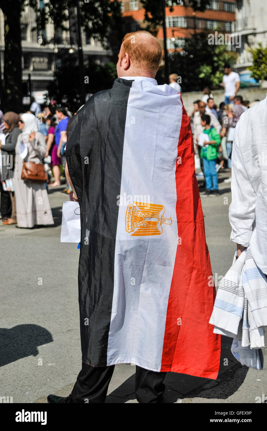 Un uomo indossa la bandiera dell'Egitto oltre le sue spalle Foto Stock