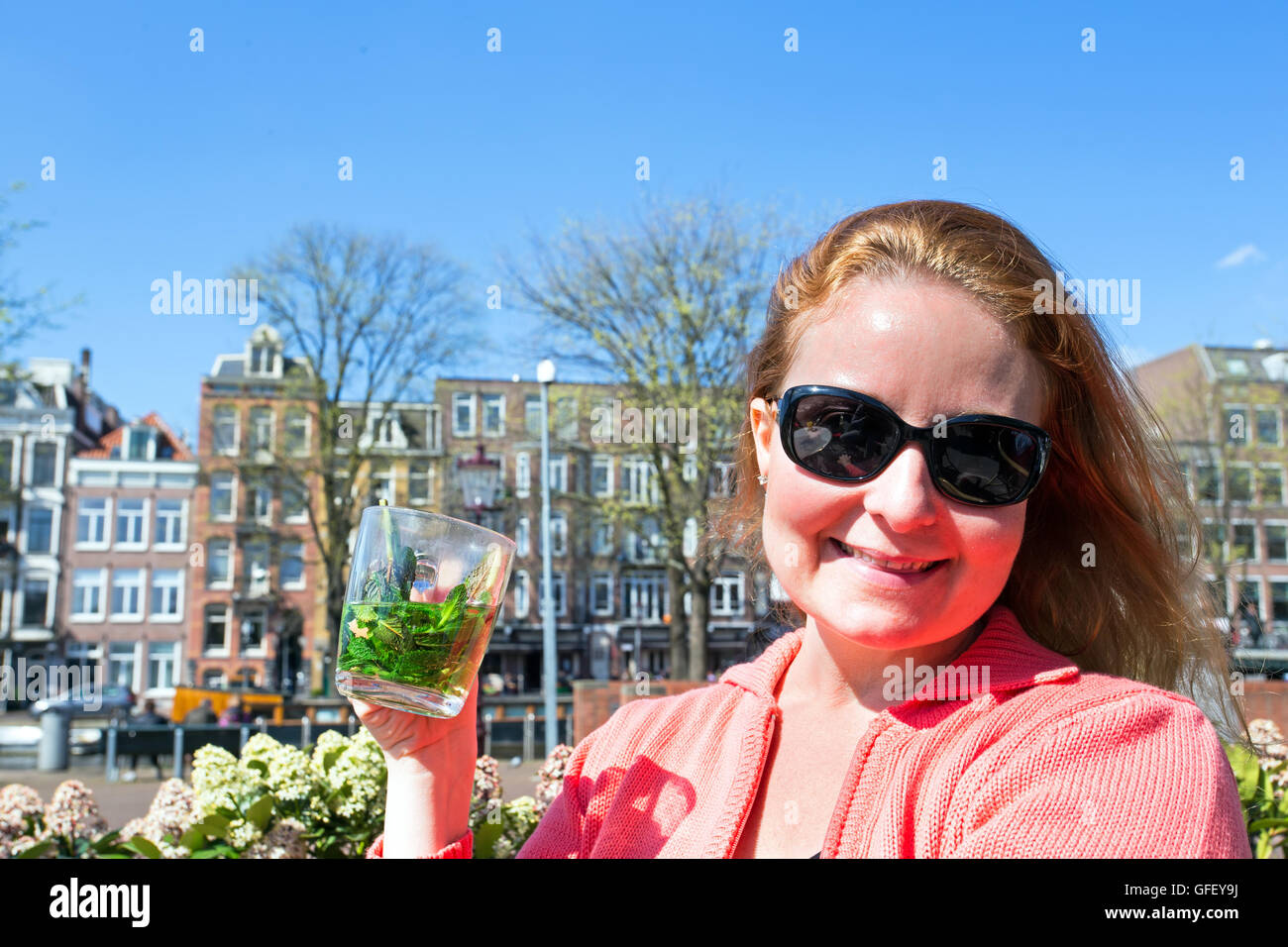 Bella giovane donna godendo un tè alla menta su una terrazza in Amsterdam Paesi Bassi Foto Stock