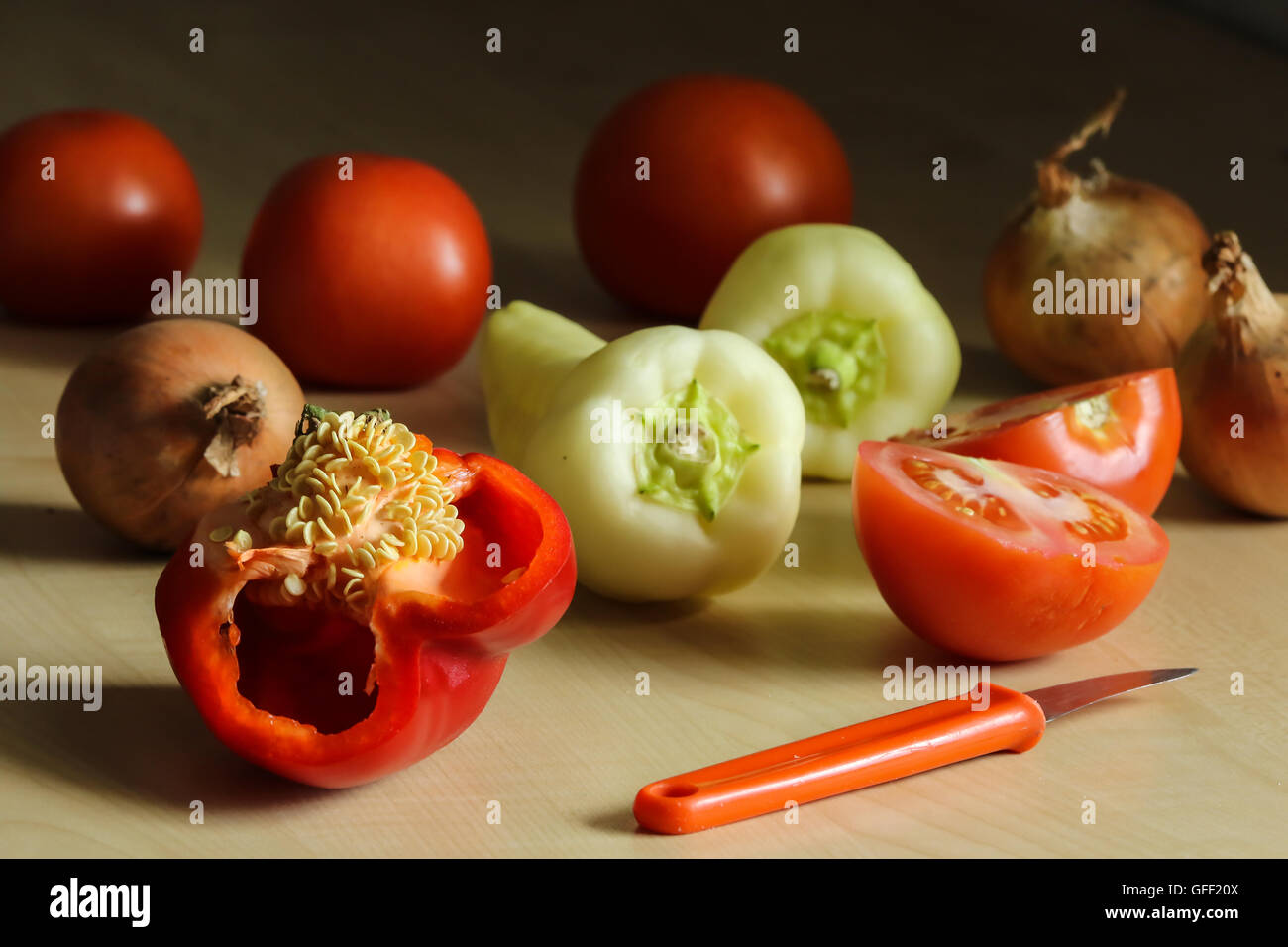 Natura morta con coltello, verdure paprica, pomodoro, cipolla close up Foto Stock