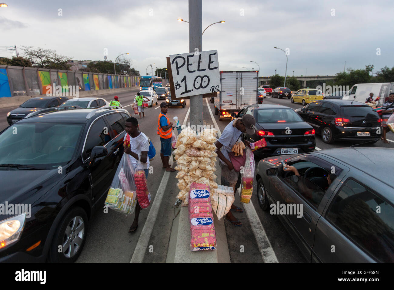 Gli abitanti di Complexo da mare, un enorme rete di favelas che affiancano la Linha Vermelha ( Linea Rossa ), la principale autostrada per l'aeroporto internazionale di Rio de Janeiro al centro della città, il lavoro come venditori ambulanti durante le ore di punta al expreessway - dal 2010 la comunità è stata recintata dall'autostrada da enormi pannelli di Perspex - secondo le autorità forniscono una barriera acustica, la gente del posto lo descrivono come un "muro della vergogna", un altro modo di nascondere i poveri. Foto Stock