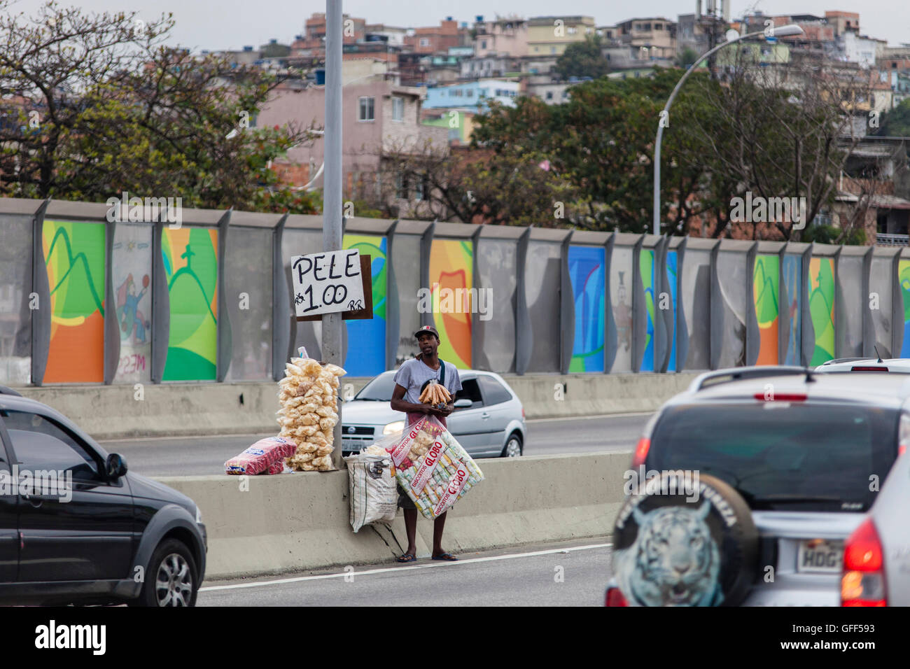 Gli abitanti di Complexo da mare, un enorme rete di favelas che affiancano la Linha Vermelha ( Linea Rossa ), la principale autostrada per l'aeroporto internazionale di Rio de Janeiro al centro della città, il lavoro come venditori ambulanti durante le ore di punta al expreessway - dal 2010 la comunità è stata recintata dall'autostrada da enormi pannelli di Perspex - secondo le autorità forniscono una barriera acustica, la gente del posto lo descrivono come un "muro della vergogna", un altro modo di nascondere i poveri. Foto Stock