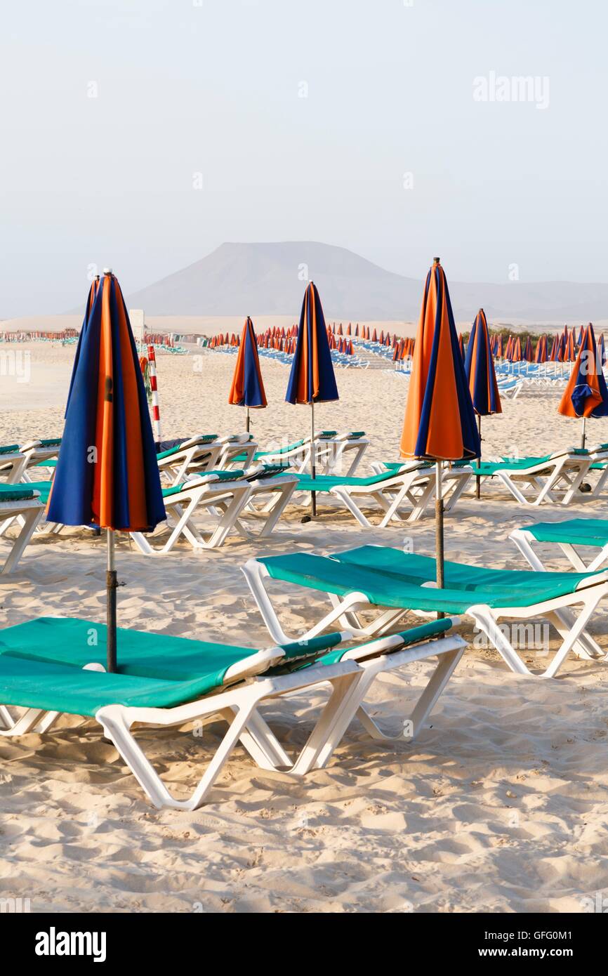 Svuotare le sedie a sdraio e ombrelloni sulla spiaggia Foto Stock