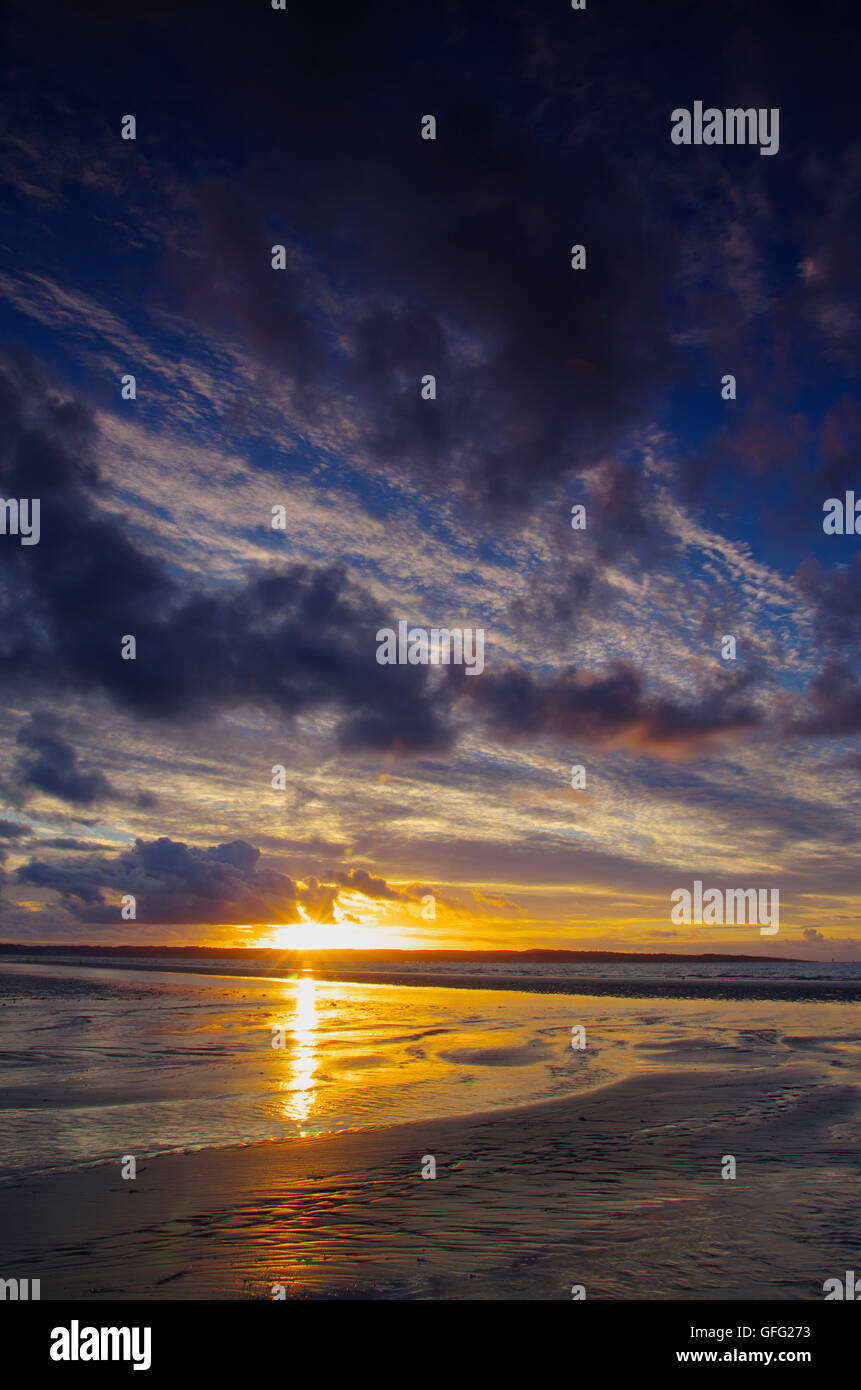 Tramonto a Penmaenmawr spiaggia verso Anglesey Foto Stock