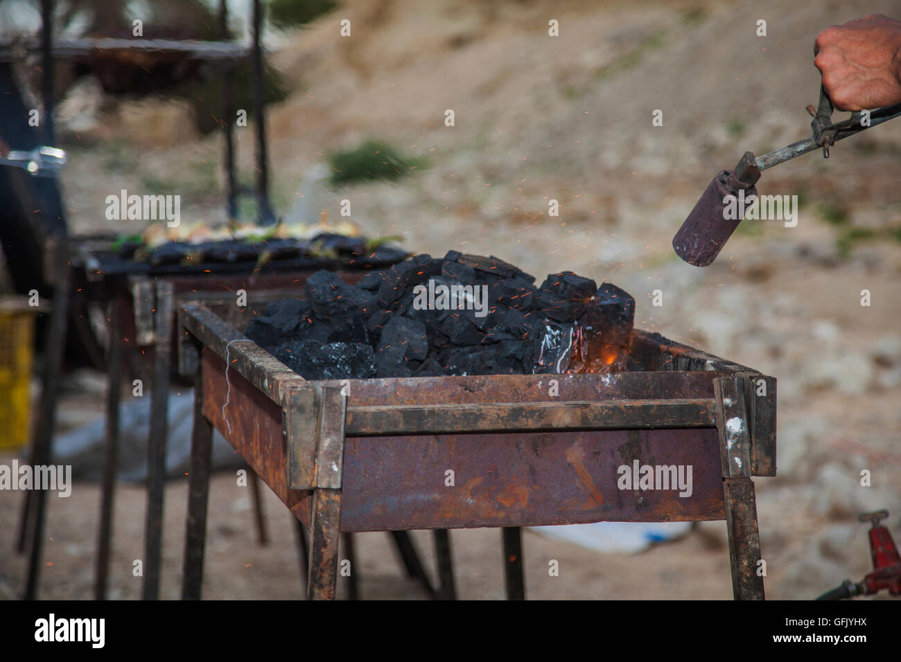 Carboni di riscaldamento su un barbecue nel campo campeggio Foto Stock